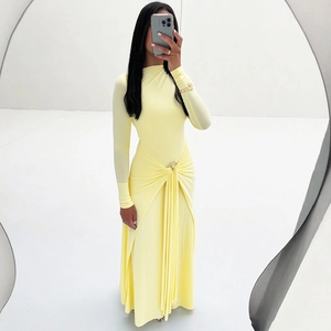 Détail des plis à la taille et boucle en métal sur la robe longue jaune clair