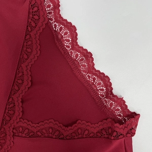 Détail d'un t-shirt rouge ajusté avec bordure en dentelle et broderie florale