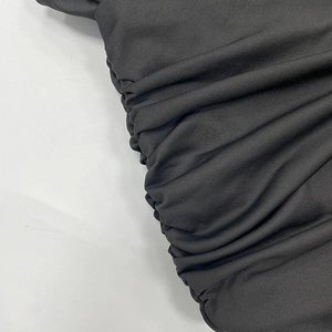 Detailed view of black ruched fabric texture and elastic knit material for women dress
