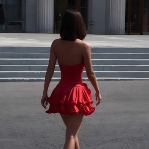 Detail view of red halter-neck dress featuring tiered ruffles and sleek backless design