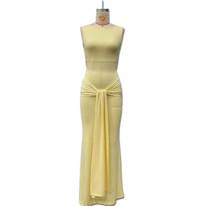 Detailed view of yellow maxi dress featuring side pleats and elegant long ribbons