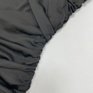 Detailed view of black ruched fabric texture with elegant pleats and stretchy finish
