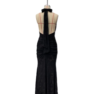 Detail of black backless fishtail dress with lace texture and elegant halter neck bow tie