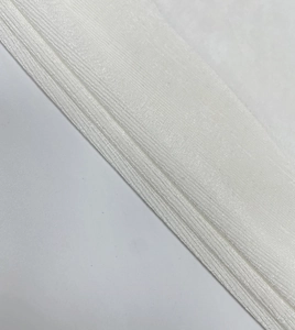 Detail shot of the white textured translucent fabric with elegant pleated layers and sheen