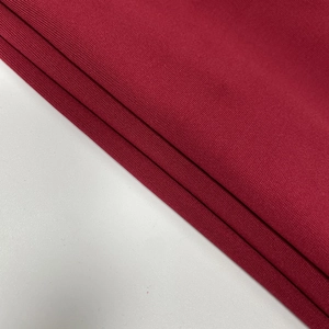 Gros plan sur la texture du tissu en maille rouge foncé avec des côtes verticales