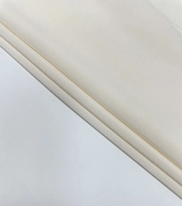 Detailed macro view of the cream ribbed knit fabric texture on this long dress