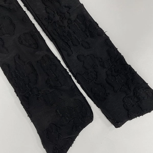 Detail of black jacquard sleeves with 3D floral texture and raw edges for women