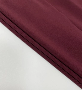 Detail shot of wine red knitted fabric with fine horizontal texture and soft stretch