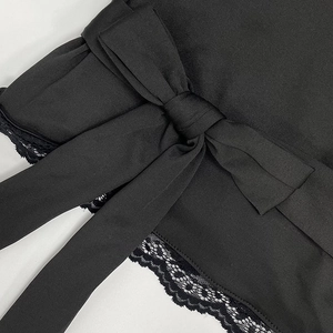 Gros plan sur un tissu côtelé noir avec un nœud central et des bordures en dentelle