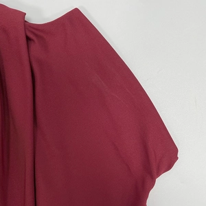 Detail view of wine red knitted fabric with clear vertical ribbed texture and soft finish