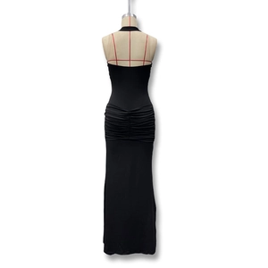 Detail view of the elegant ruching and bodycon mermaid silhouette on a black maxi dress
