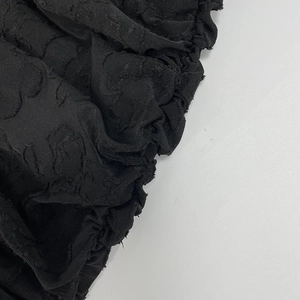 Macro shot of black jacquard fabric featuring iconic interlocking G embossed pattern