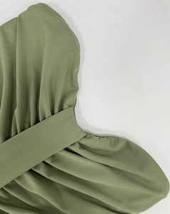 Close-up of olive green slim fit dress featuring pleated fabric and hidden zipper detail