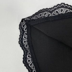 Détails macro de la dentelle noire délicate et des coutures sur un t-shirt ajusté
