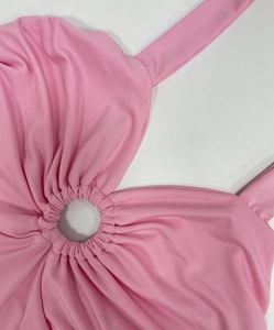 Detail of pink bodycon dress featuring central ring cutout and ruched fabric texture