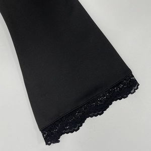 Gros plan détaillé de la dentelle noire sur l'ourlet d'un t-shirt ajusté à manches longues