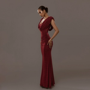 Detailed close-up of dark red ruched fabric with elegant cowl neck and floor-length design