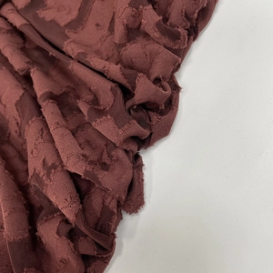 Macro detail of wine red floral textured fabric with 3D jacquard and mesh design