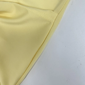 Macro shot of cream yellow knitted rib fabric texture and high-quality sewing details