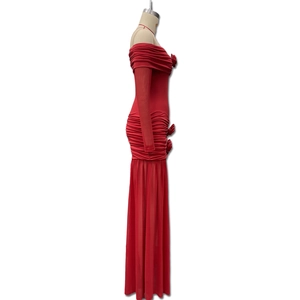 Detail view of red off-shoulder dress featuring ruched fabric and 3D floral accent