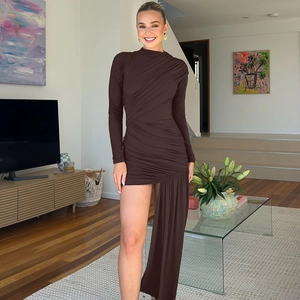 Detail of ruched dark brown dress showing asymmetrical floor-length trailing hem and slim fit