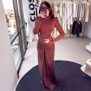 Detail of waist cut-out and draped pleats on an elegant brown long-sleeve maxi dress