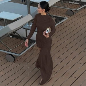 Detail of dark brown ruched fabric and asymmetric hemline on a slim-fit autumn dress