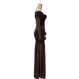 Detailed view of dark brown ruched maxi dress featuring off-shoulder design and side floral accent