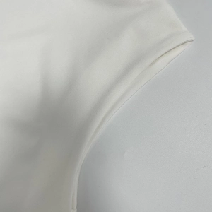 Close-up of white twill cotton fabric texture and stitching details of the dress