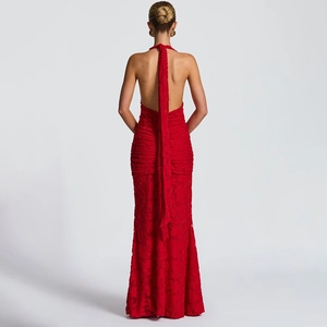 Detail of red backless halter dress with long ribbon and intricate lace texture