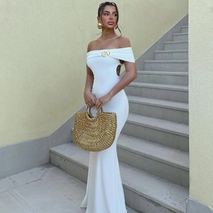 Gros plan sur l'ornement doré et la découpe de cette robe moulante blanche élégante