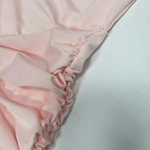 Dettaglio ravvicinato dell'arricciatura e del tessuto elastico rosa di un abito sexy