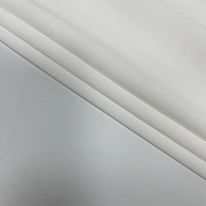 Close-up of white ribbed knit fabric texture with soft layers on a sleek mini dress