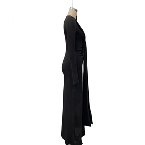 Détail des fronces latérales et de la fente haute sur une robe moulante noire à manches