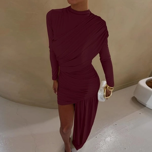 Detail view of ruched fabric and asymmetrical hemline on deep red long sleeve dress