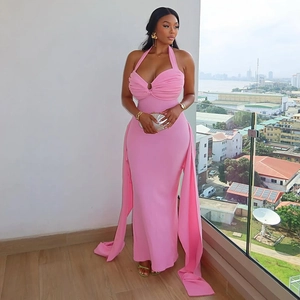 Detail of pink halter dress featuring ruching, metal ring hardware, and flowing floor-length ties