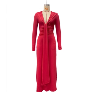 Détail de robe rouge à manches longues avec décolleté en V profond, lien et plis à la taille