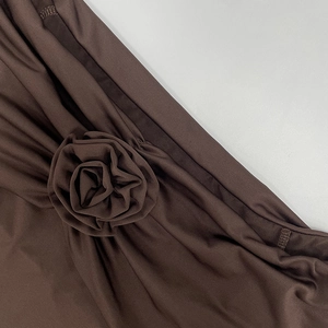Macro shot of a dark brown fabric rose with pleated texture and fine stitching
