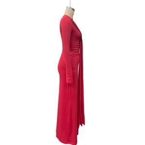 Détail d'une robe rouge à manches longues avec fronces latérales et rubans décoratifs