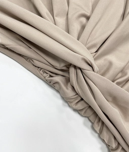 Détail de la robe en maille champagne avec nœud croisé et texture en tissu côtelé