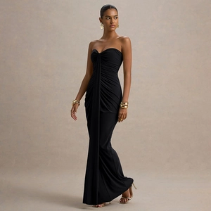 Macro view of the pleated detail and draped fabric on this black floor-length dress