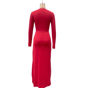 Détail de la robe rouge ajustée à manches longues montrant le tissu en maille élastique