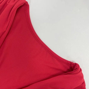 Gros plan sur les coutures propres et la texture tricotée fine d'une robe rouge