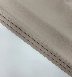 Gros plan détaillé du tissu en maille beige montrant la texture plissée et douce