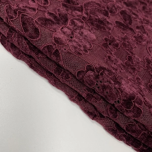 Gros plan sur le tissu en dentelle bordeaux avec motifs floraux et texture douce