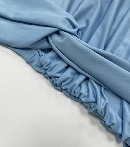 Détail du nœud torsadé et de la taille élastique plissée sur une robe bleu clair