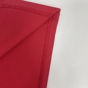 Détail de la couture précise et de la finition de l'ourlet sur la robe rouge moulante