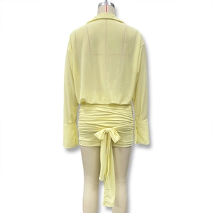 Back view of yellow slim-fit two-piece dress set with oversized bow tie and pleated skirt