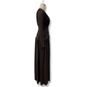 Detail of waist pleats and gathered fabric on a brown long sleeve maxi dress