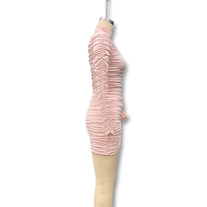 Detail view of pink ruched bodycon dress with long sleeves and elegant side folds